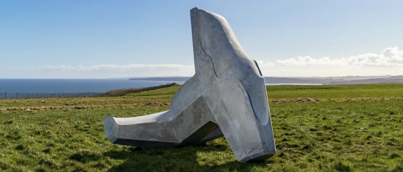 Ryan Gander’s concrete sculpture in the shape of a dolos, with sea views behind it