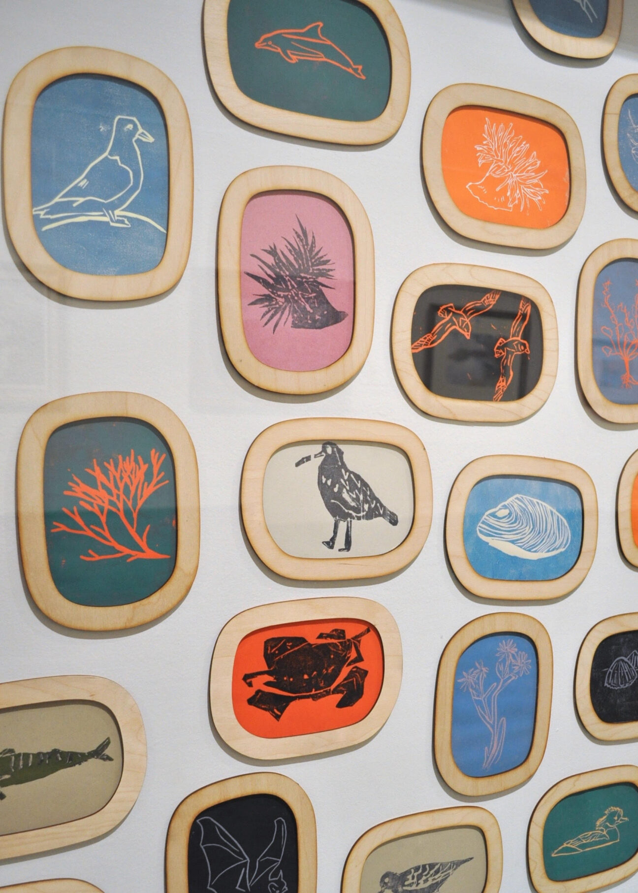A gallery display filled with colourful lino prints