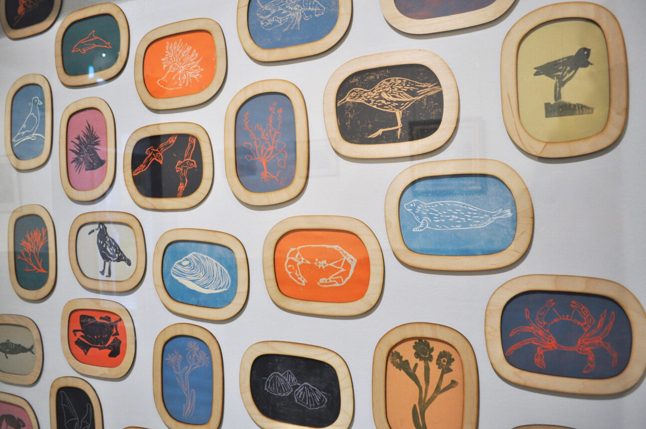 A gallery display filled with colourful lino prints