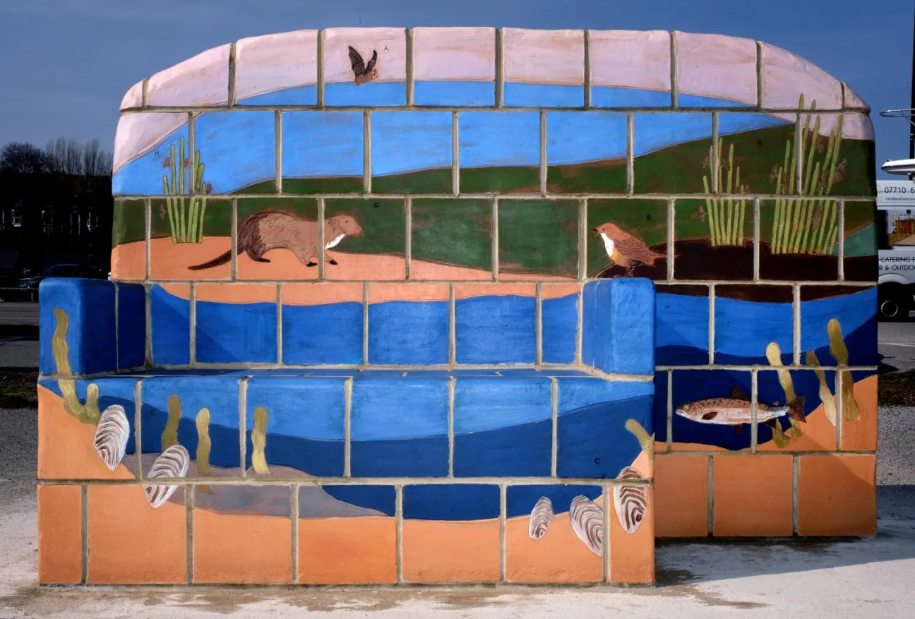 A colourful ceramic bench, depicting estuary nature, including a bat, otter, freshwater pearl mussels and fish.