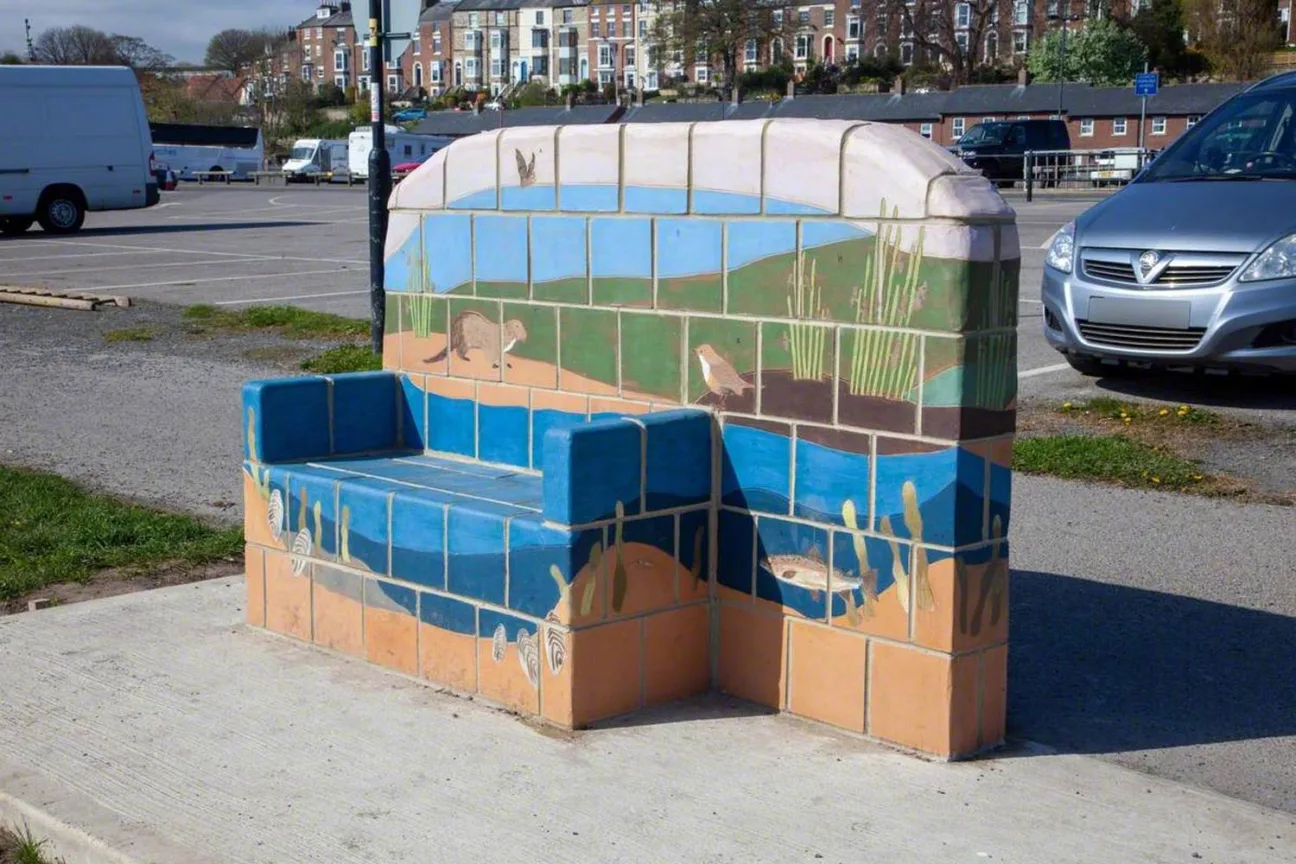 A colourful ceramic bench, depicting estuary nature, including a bat, otter, freshwater pearl mussels and fish.