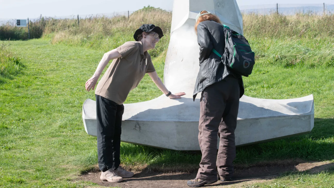 A staff member talks to a visitor about the dolos sculpture in the grounds of Scarborough Castle